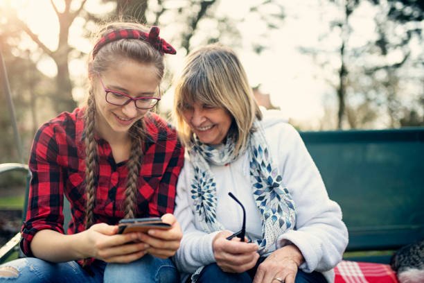 A young and an old lady watching in mobile phone