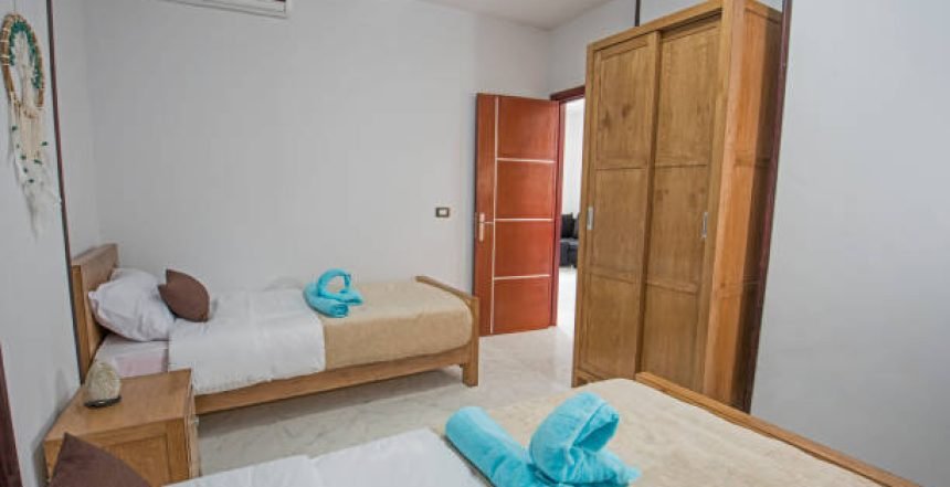 luxury apartment bedroom with twin single beds and wardrobe