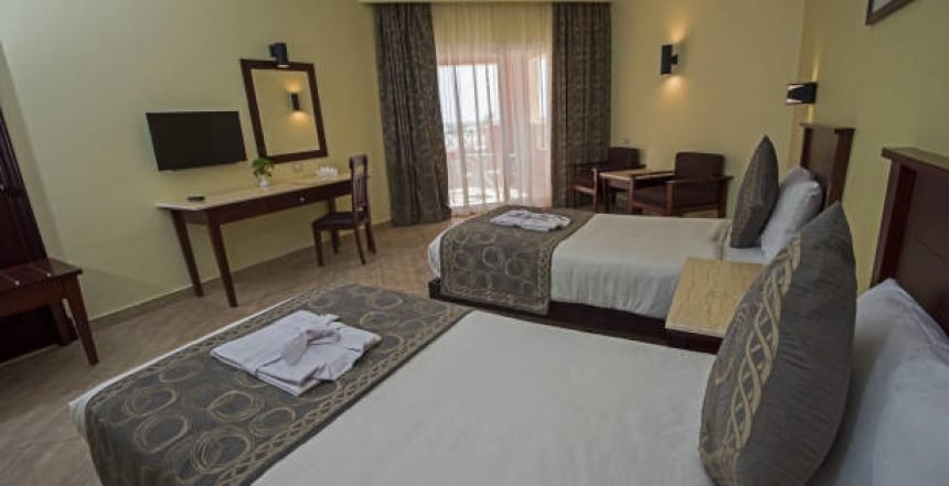 A room with two beds, table chair etc.